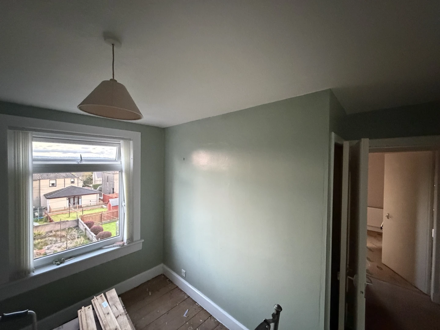 Sage green room walls with white ceiling, window surround and skirting