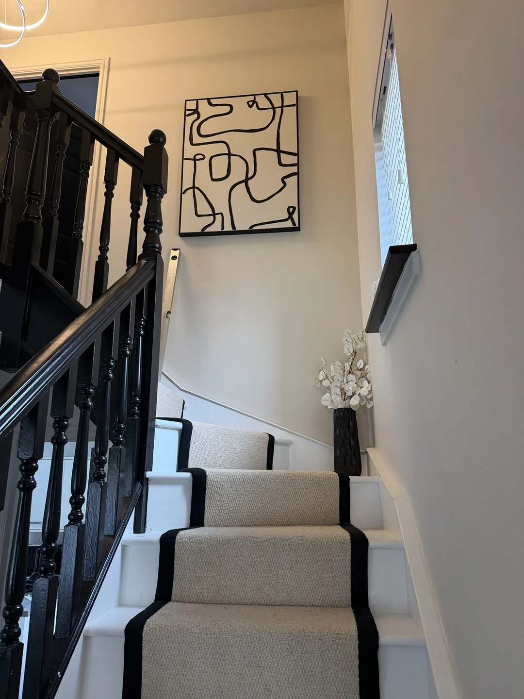 Neutral painted stairwell with black banister and white trim
